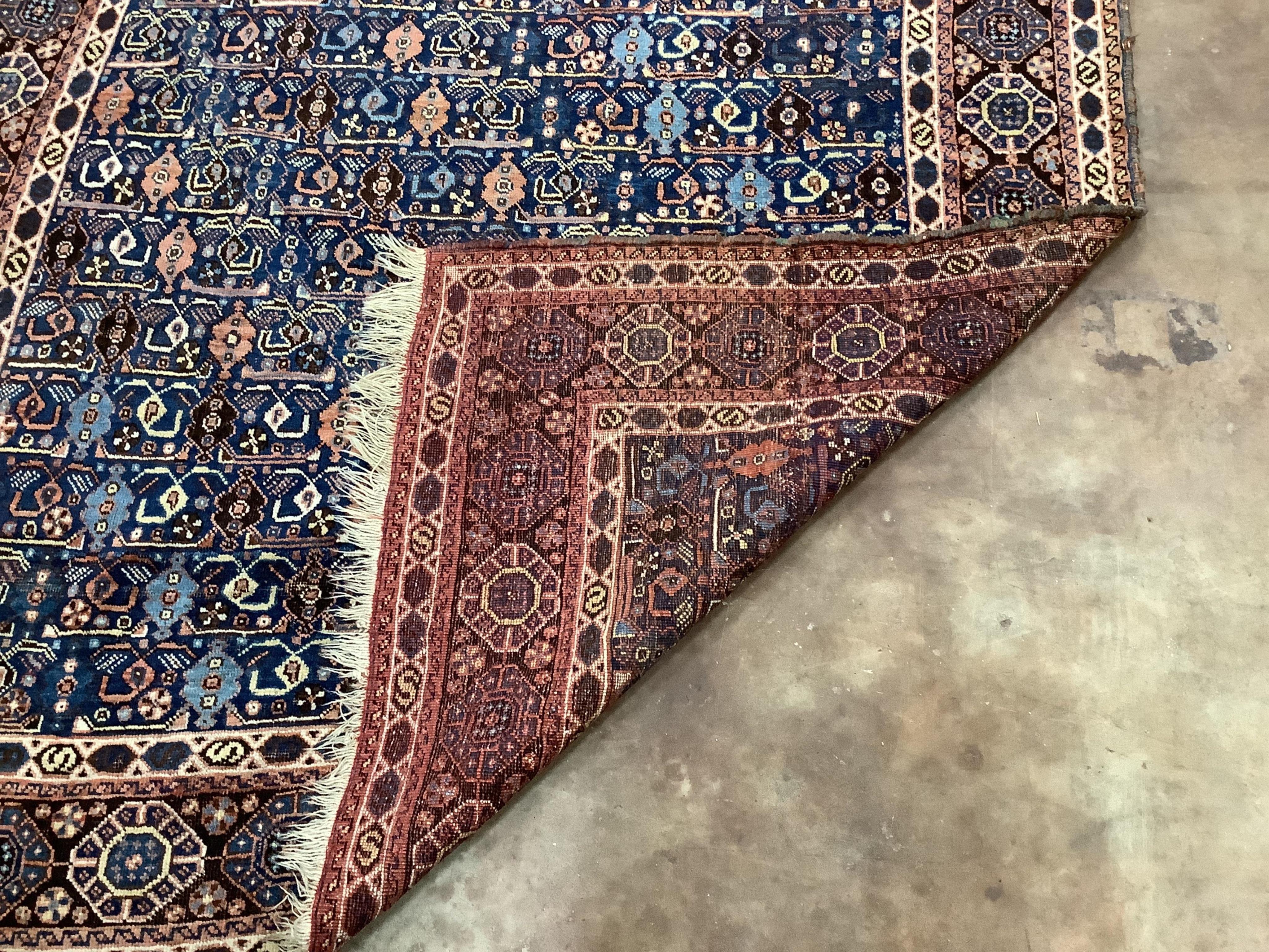 A Caucasian square shaped rug, woven with rows of hooked devices and shaped lozenges, on a blue field, 142 x 144cm